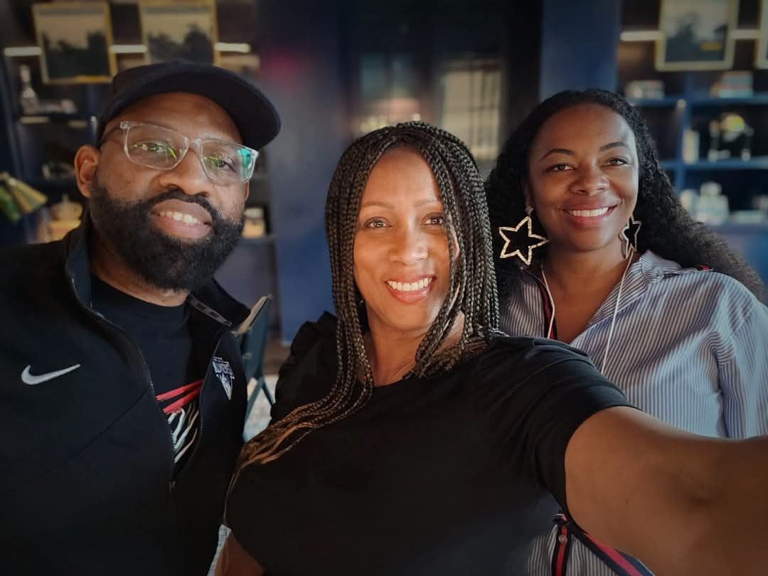 Three friends smiling and posing for a selfie together